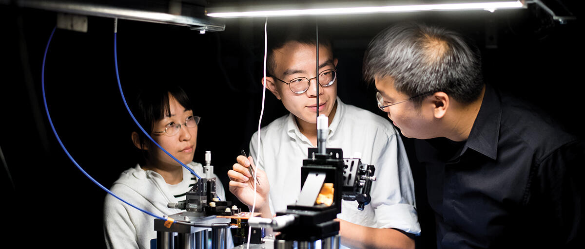 Norman Yao and 2 students working together in the lab