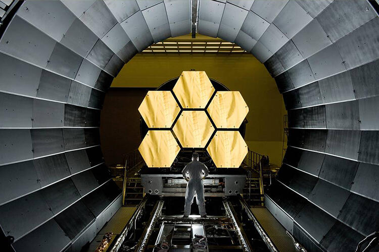 Dramatic image of the panes of the James Web telescope with man standing in front