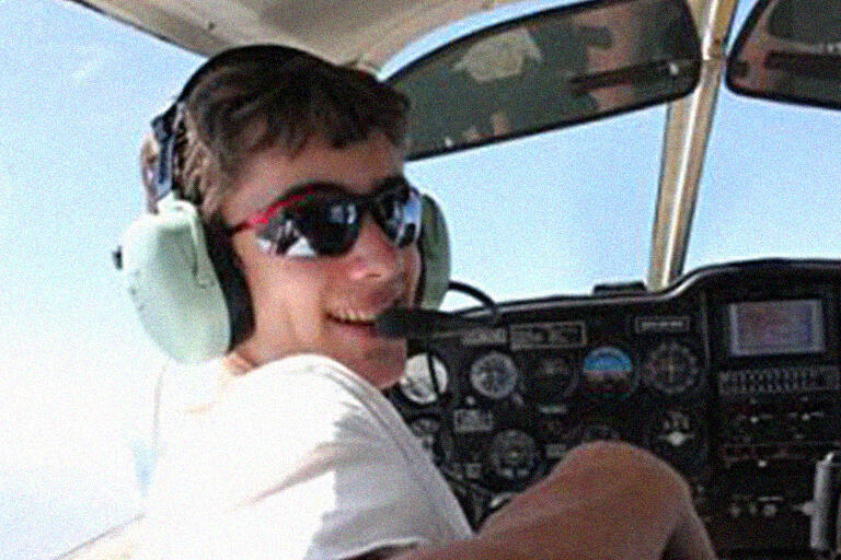 Jeremy Axelrod with headphones on, at the controls of an airplane