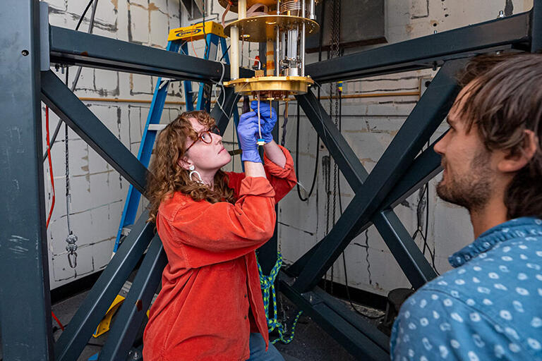 Maggie Reed works on TESSERACT's dilution refrigerator