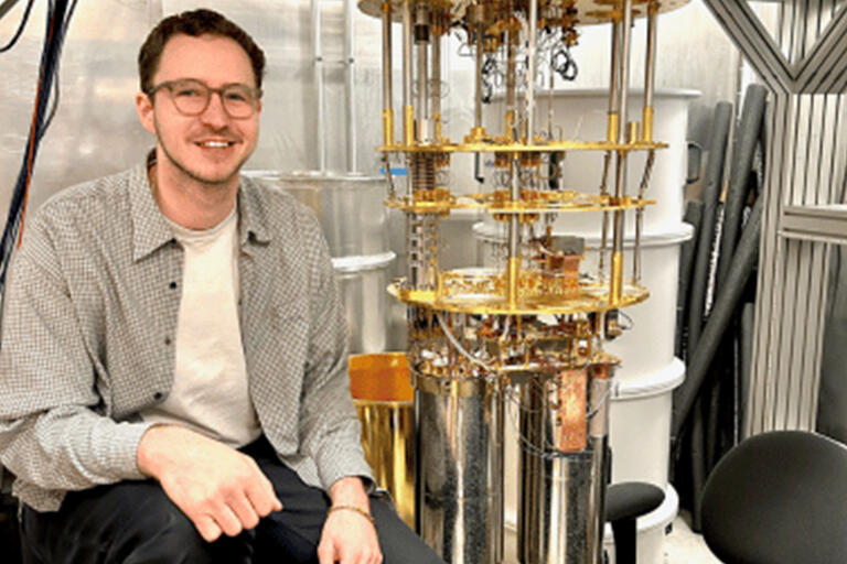 Noah Goss next to cryostat