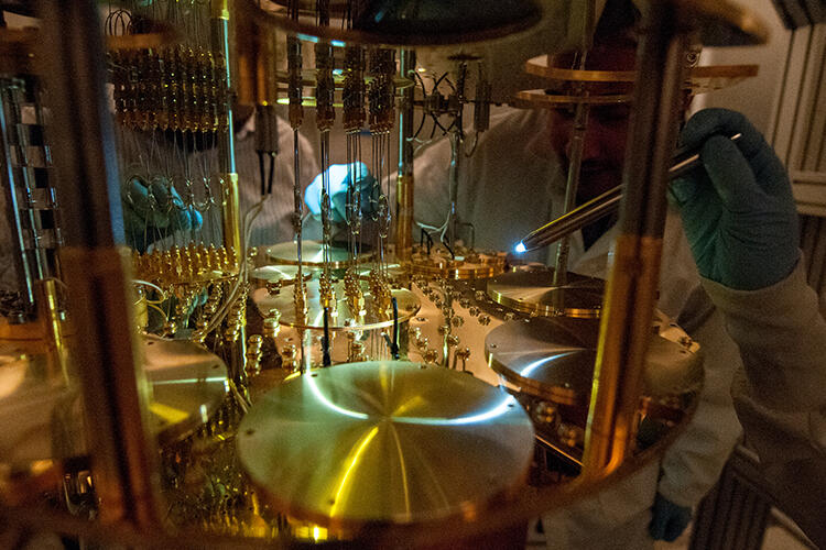 Photo depicting scientists shining a spotlight on the wires of quantum computing components