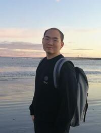 photo of Shuo Ma in front of a body of water at sunset