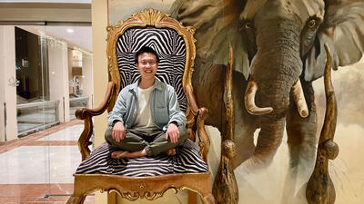 Chunxiao Liu sitting next to a picture of an elephant